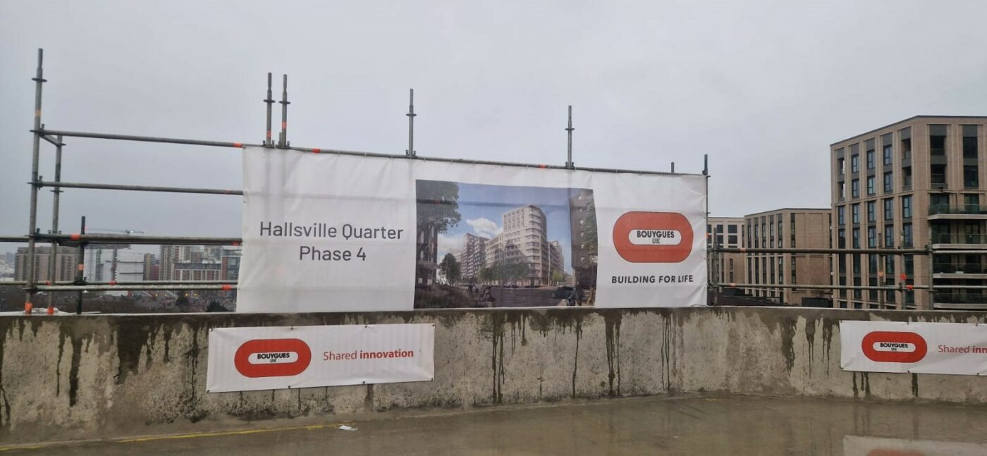 A construction site and banner of Hallsville Quarter student accommodation in East London.