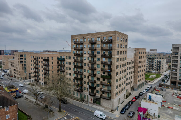 A large apartment block with private balconies to accommodate their private flats. Alongside a green courtyard and parking spaces.