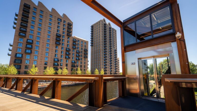 A modern building featuring large glass windows, set against a backdrop of the sky, showcasing its architectural design.