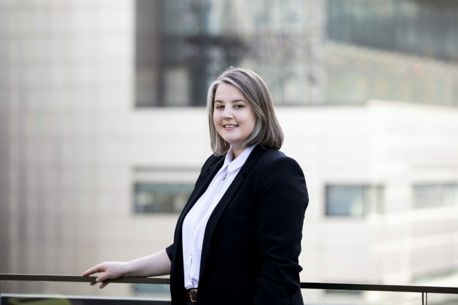 A woman called Rebecca Carter in a black suit, outside on a balcony