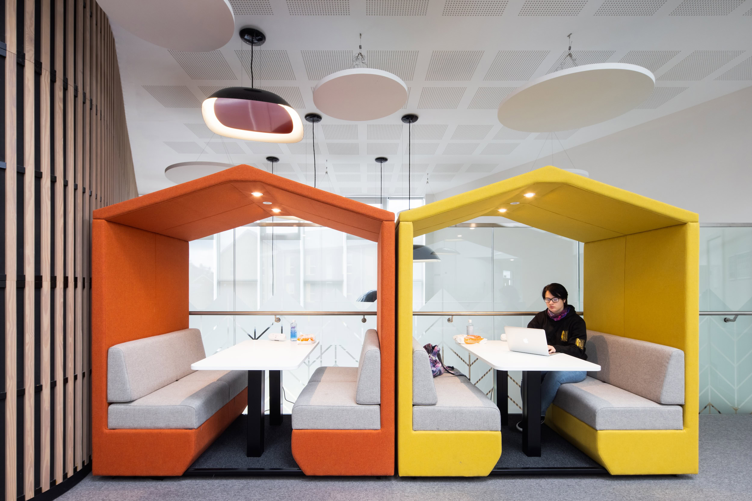 A modern, unique, colourful working space, with two individual booths coloured in orange and yellow.