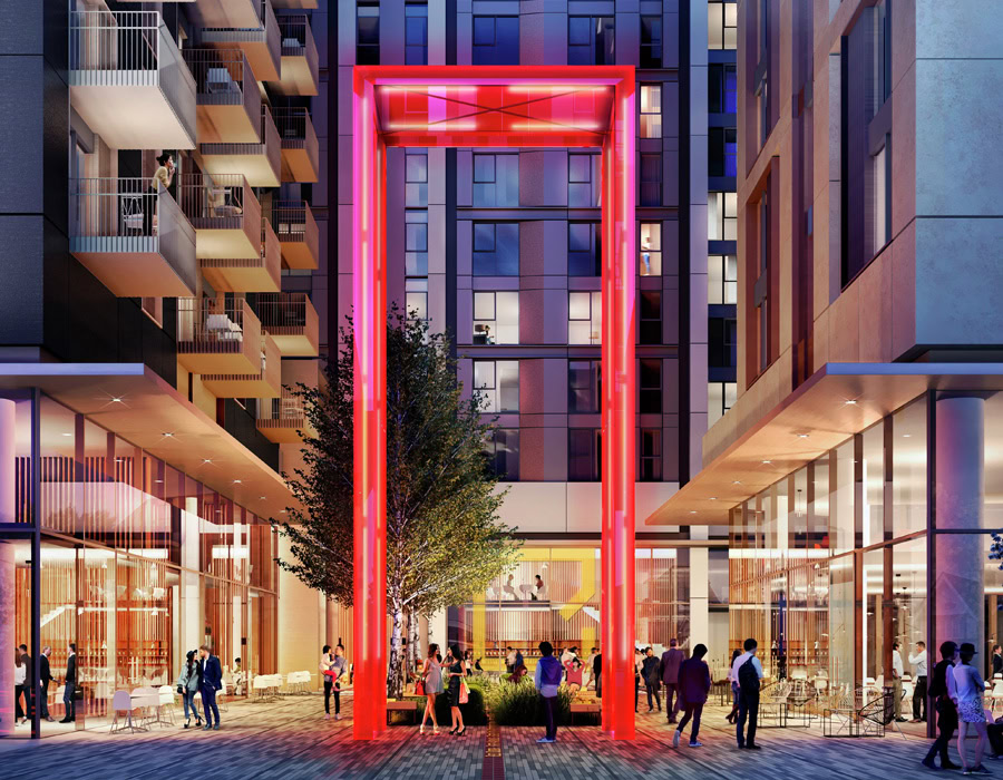 A modern urban plaza with a large illuminated red frame sculpture. People are socialising around and a tall tree adds greenery to the sleek buildings.