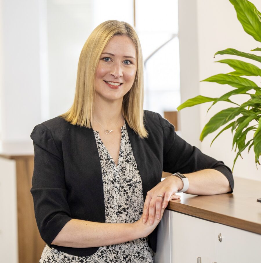 Woman in dress and black jacket in corporate setting