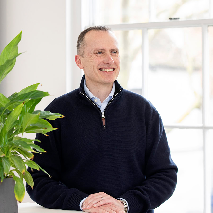 Man standing next to plant pot
