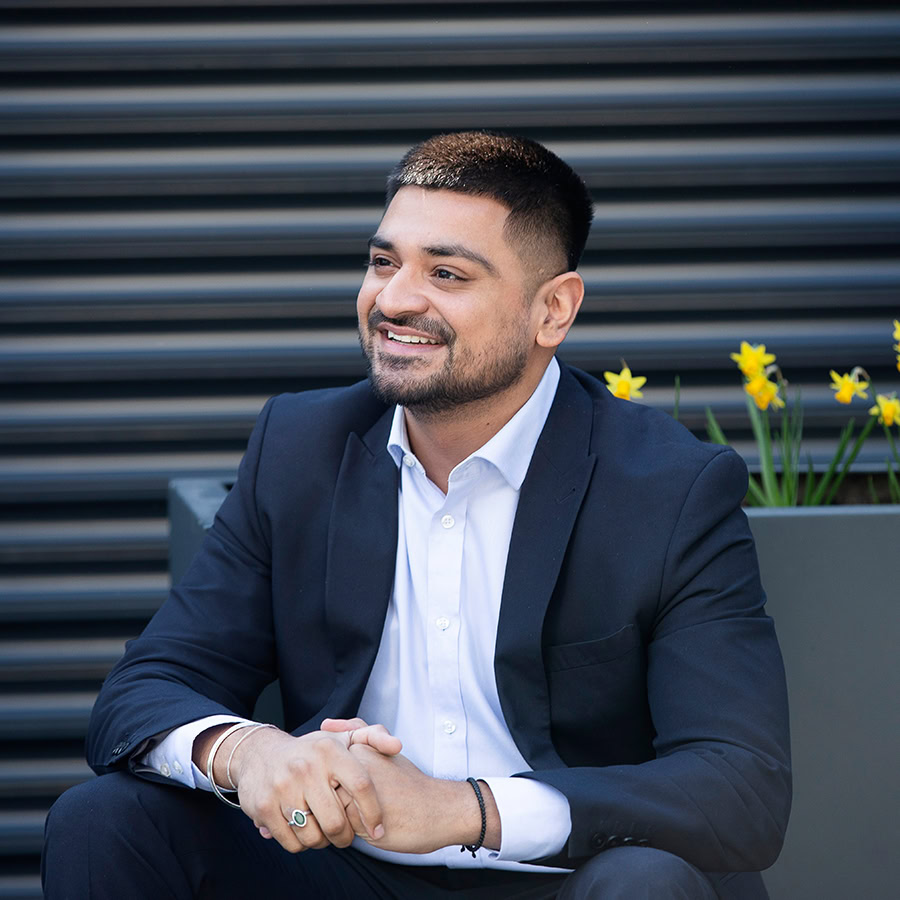 Man outdoors smiling and sitting on a chair