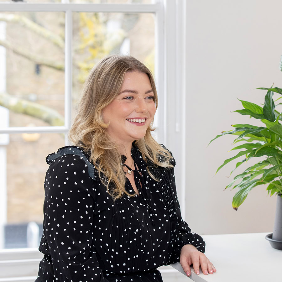 Woman sitting on a chair smiling.