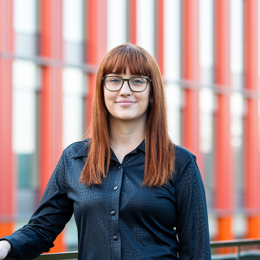 Photo of a woman wearing glasses in a black shirt on a rooftop.
