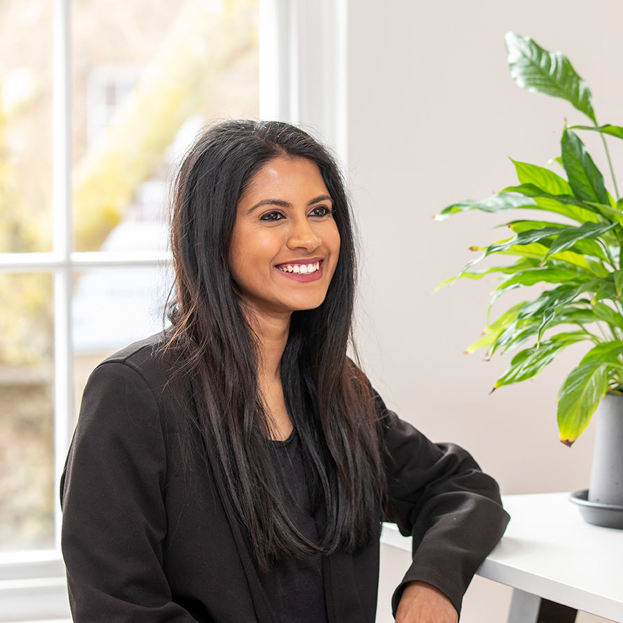 Woman sitting on a chair next to a plant pot