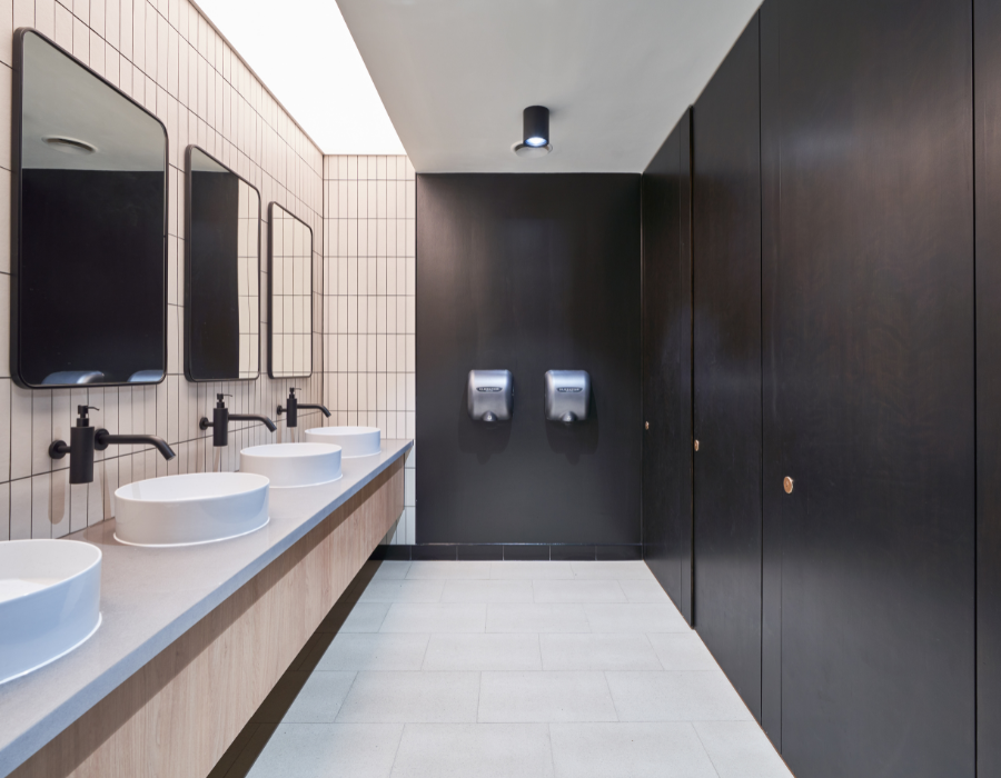 Toilet inside office building, with mirrors, sinks, taps and doors.